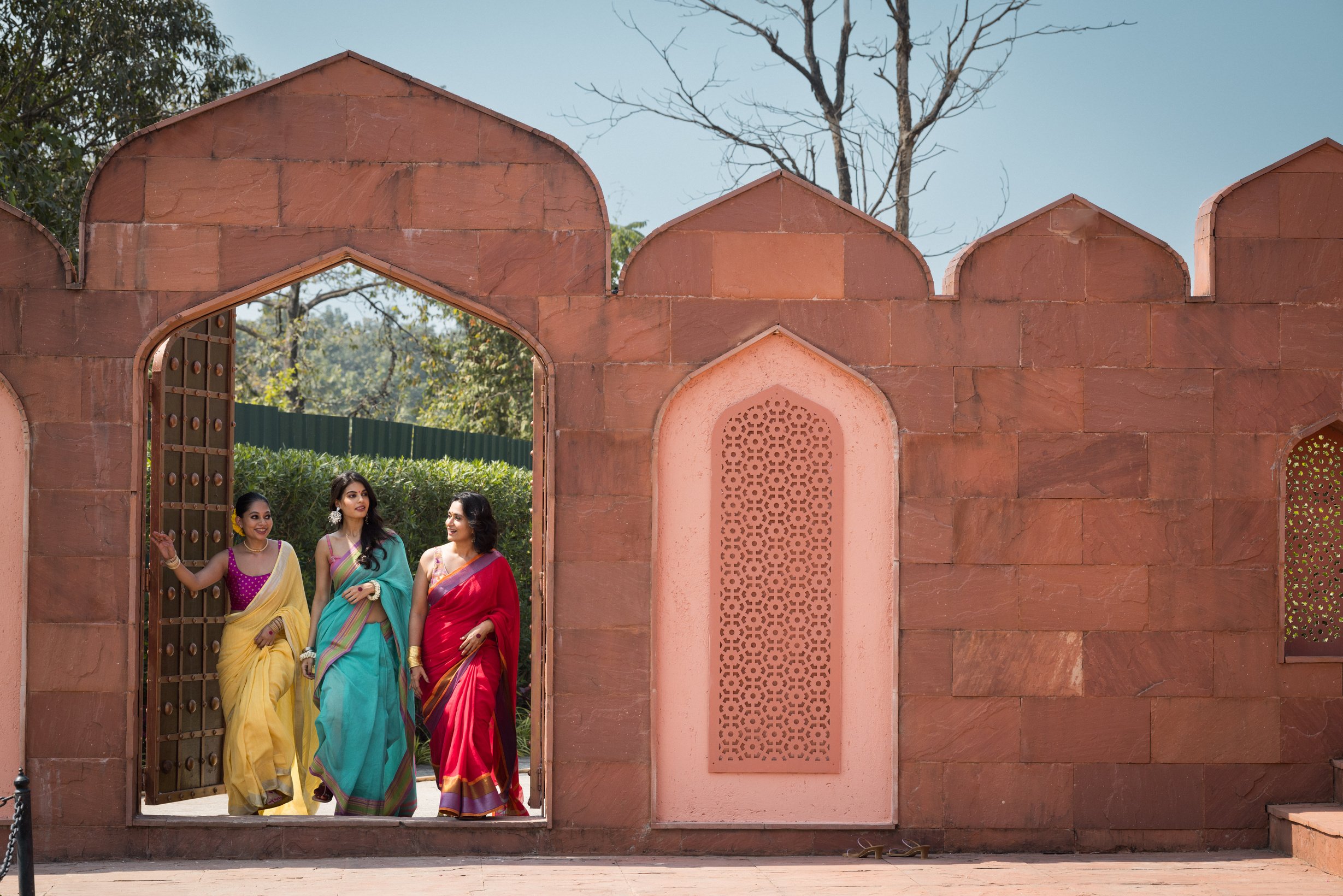 Women Wearing Sarees Outside an Indian Architecture