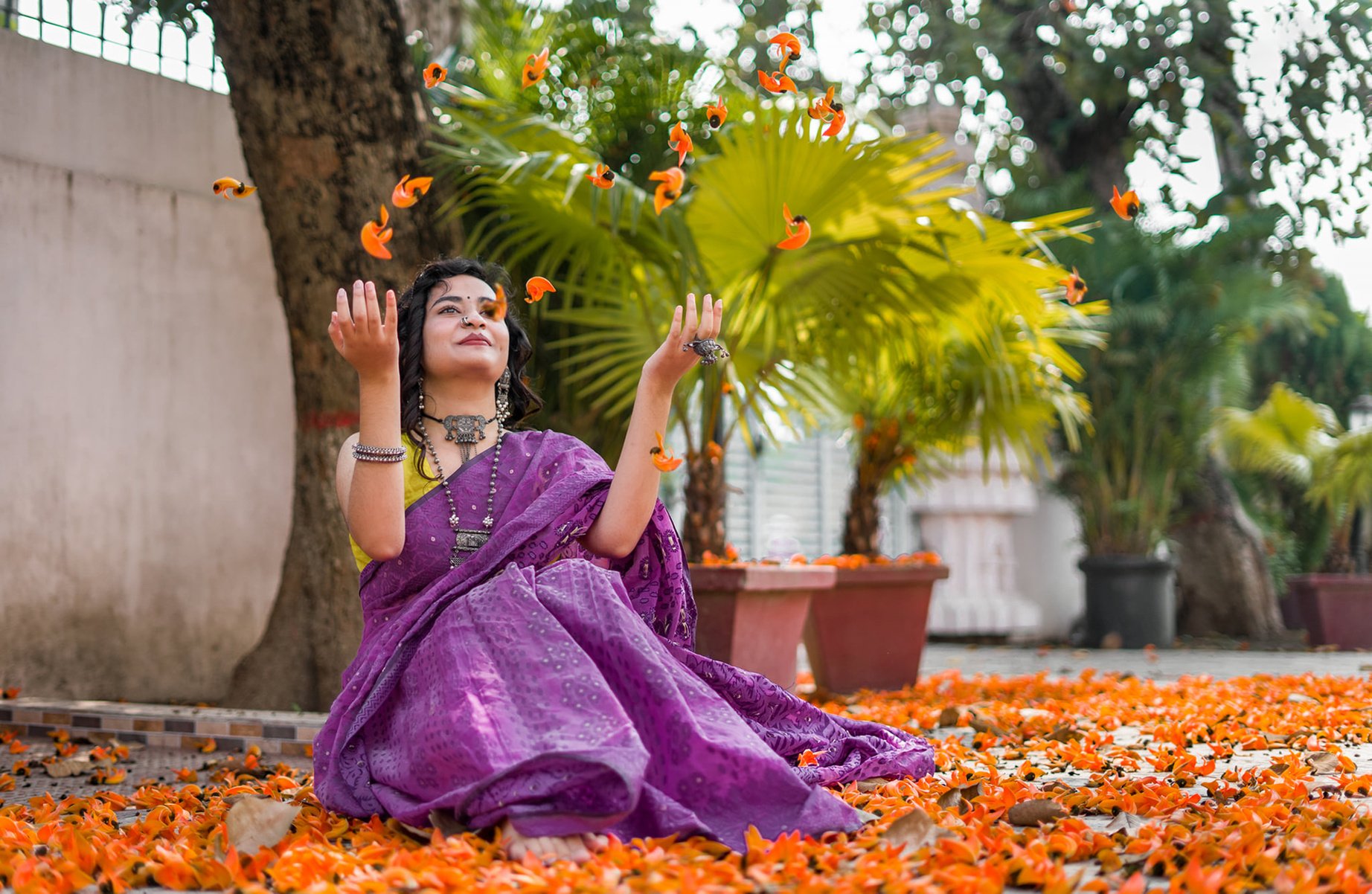 A Woman in Purple Saree Sitting on Ground